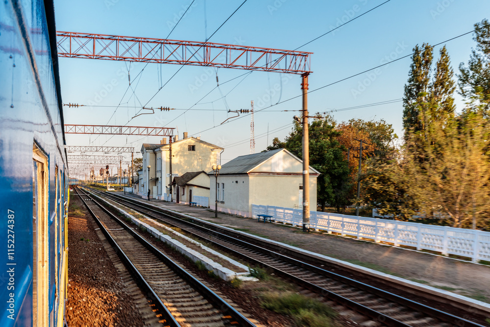 Fototapeta premium A train is traveling down the tracks with a blue and white train car