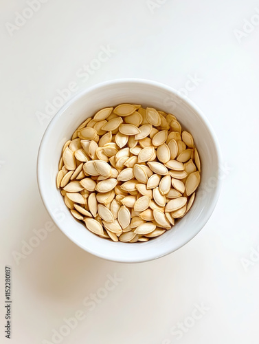 Delicate pumpkin seeds showcased in a pristine white bowl, inviting healthy snacking from a minimalist perspective