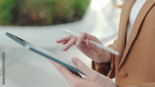 Happy Asian Businesswoman Planning in an Outdoor Workspace. Hybrid Work in Urban Greenery, Smiling Business woman Using Tablet. Joyful Manager Writing Emails in a Park., Remote Work Lifestyle