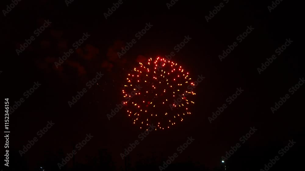 gold red blue sparks scattering fireworks on the black night sky over the city. General plan gold red blue sparks scattering fireworks on the black night sky over the city. General plan