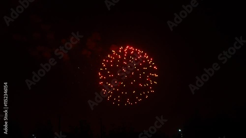 gold red blue sparks scattering fireworks on the black night sky over the city. General plan