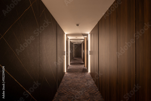 Interior of a long hotel corridor with wooden walls