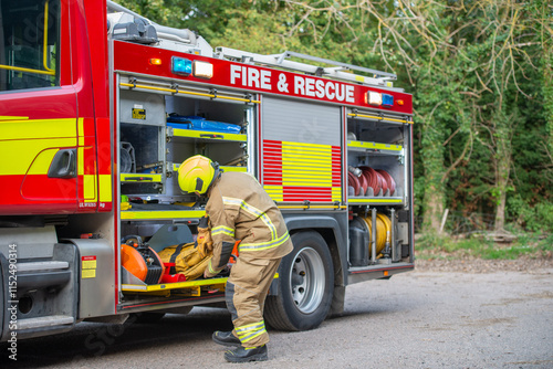 Emergency firefighter taking equipment from a fire engine