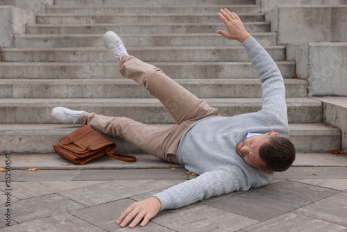 Injured man on stairs outdoors after fall. Dangerous accident