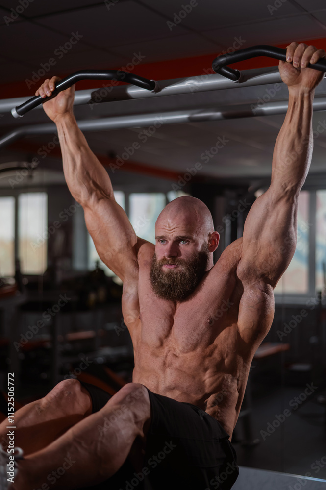 A Caucasian man hangs on a horizontal bar and raises his legs. Vertical photo. A Caucasian man hangs on a horizontal bar and raises his legs. Vertical photo.