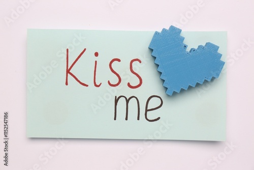 Card with phrase Kiss me and blue heart on white background, top view photo