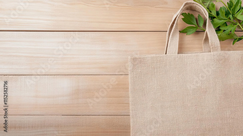 Natural jute bag on wooden surface with green leaves, eco friendly choice