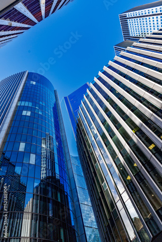 skyscraper buildings in business district, London City. Blue sunny day sky. Low angle view. Europe financial economy, merger and acquisition, or modern architecture concept, vertical