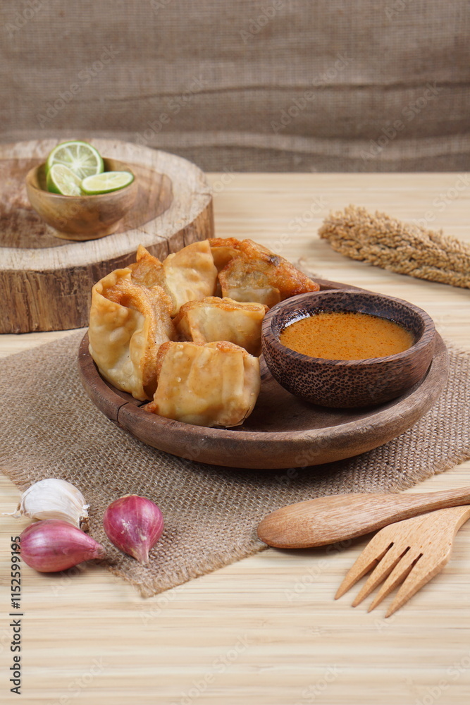 Fototapeta premium batagor,is a street food that is very popular in Indonesia.made from fish, tapioca and seasoning wrapped in dumplings then fried. Served with spicy peanut sauce. photographed with studio light