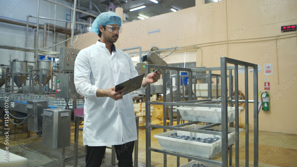 Production control supervisor inspects and controls the operation of each step in the production line of a canned fish factory