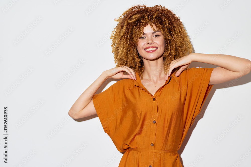 Smiling woman with curly hair in an orange dress against a white background Natural beauty and confidence are showcased through joyful expression and stylish attire Smiling woman with curly hair in an orange dress against a white background Natural beauty and confidence are showcased through joyful expression and stylish attire