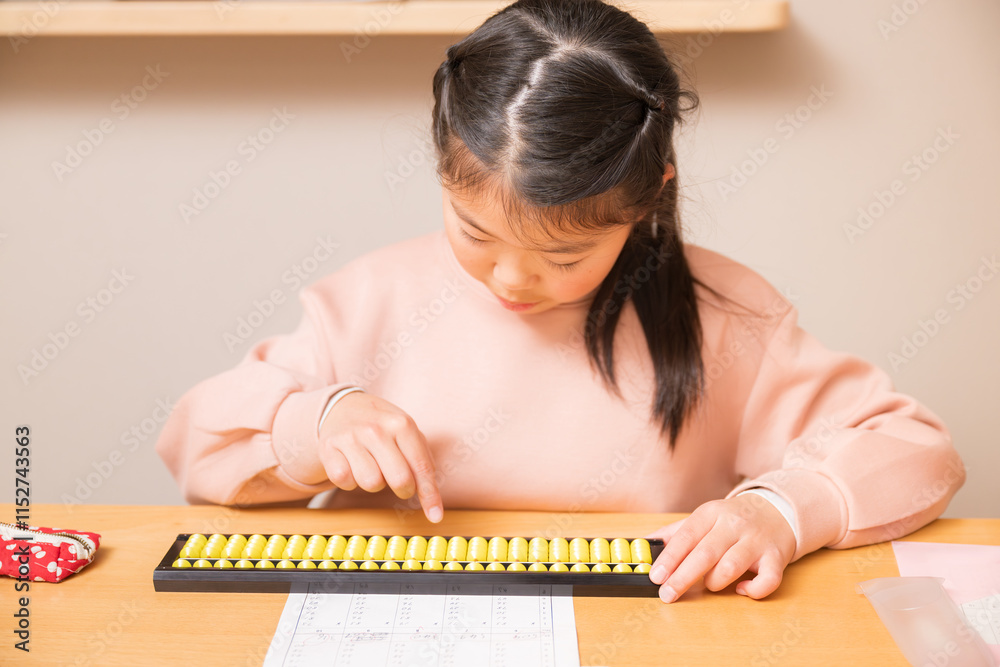机でそろばん(珠算)をする小学生