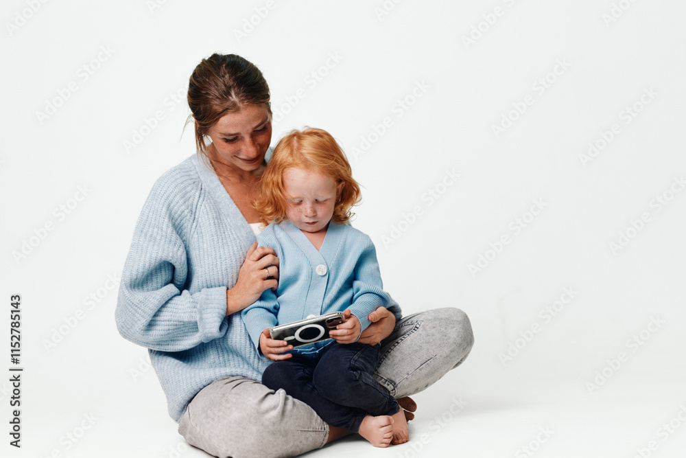 Mother and child playing with toy remote control in playroom with white background, happy family love and fun concept Mother and child playing with toy remote control in playroom with white background, happy family love and fun concept