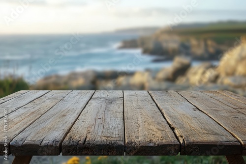 Rustic wooden table overlooking scenic ocean coast. photo