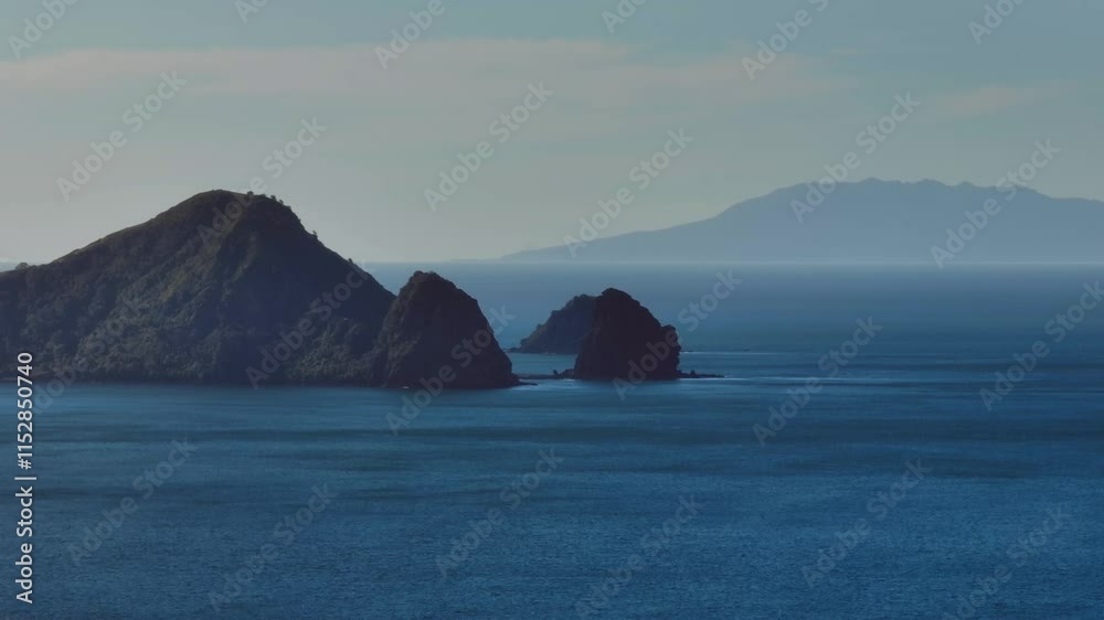 Tranquil ocean scene with dramatic coastal peaks. Misty mountains of Great Barrier Island in the distance. Peaceful, serene view. , PORT CHARLES, COROMANDEL PENINSULA, NEW ZEALAND Tranquil ocean scene with dramatic coastal peaks. Misty mountains of Great Barrier Island in the distance. Peaceful, serene view. , PORT CHARLES, COROMANDEL PENINSULA, NEW ZEALAND