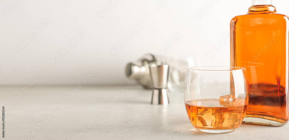 Bottle and glass of cold whiskey on light background Bottle and glass of cold whiskey on light background