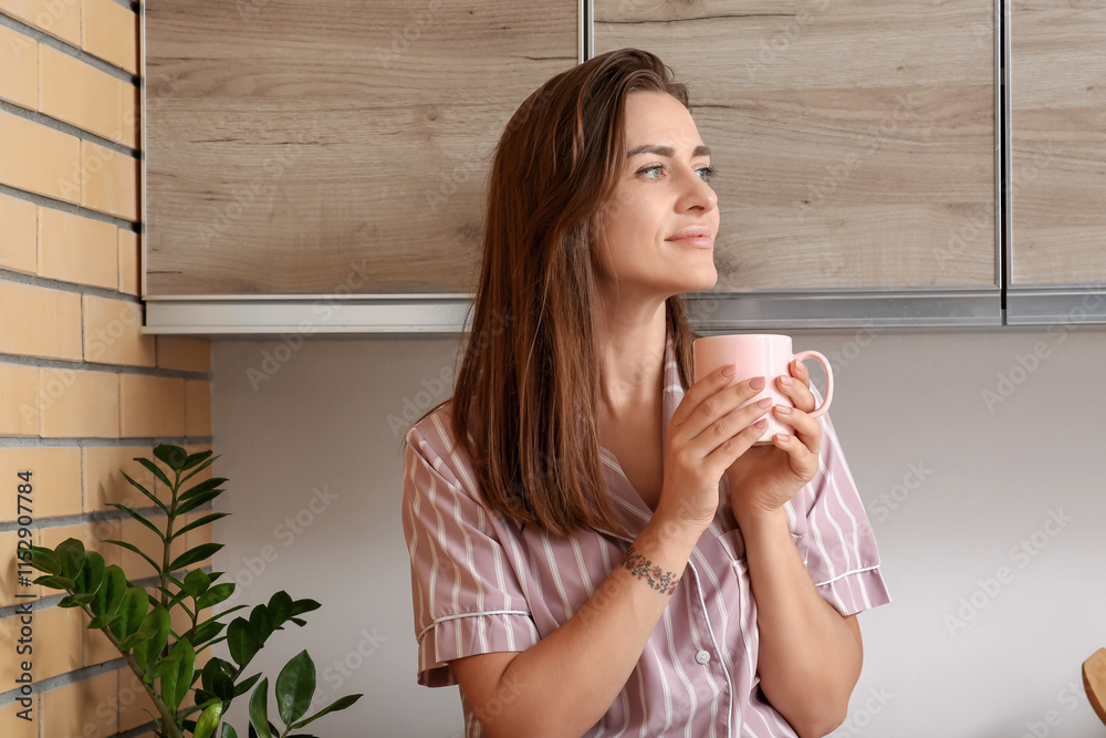 Young woman with cup of coffee in kitchen Young woman with cup of coffee in kitchen