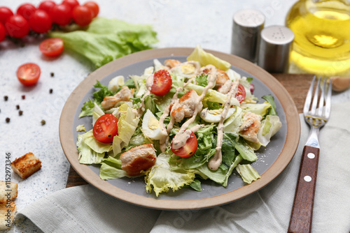 Plate with tasty chicken Caesar salad and ingredients on white background, closeup