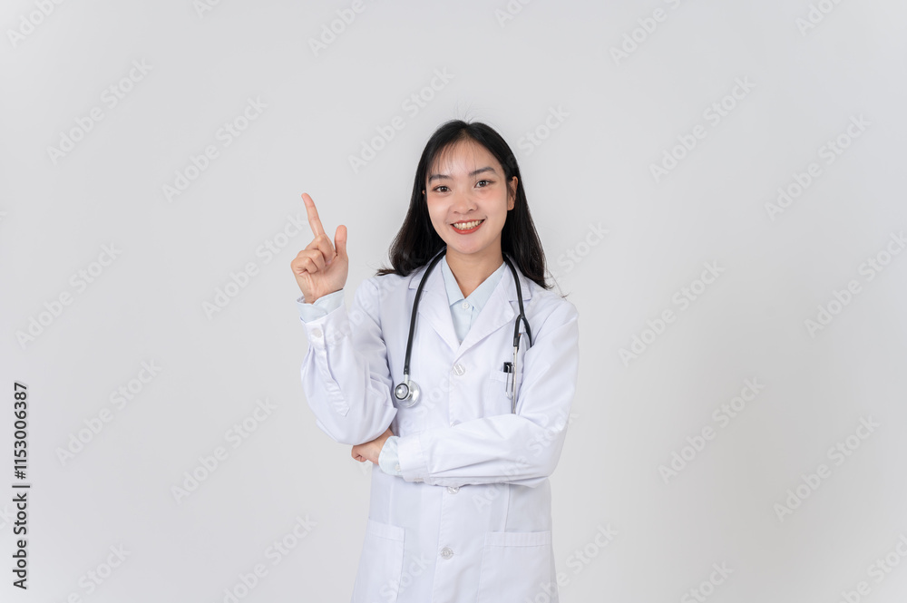 A positive Asian female doctor pointing her finger at an empty space as if recommending an option. A positive Asian female doctor pointing her finger at an empty space as if recommending an option.