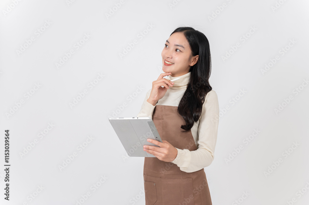 A charming Asian female cafe staff or waitress in a uniform holding a digital tablet, looking upward A charming Asian female cafe staff or waitress in a uniform holding a digital tablet, looking upward