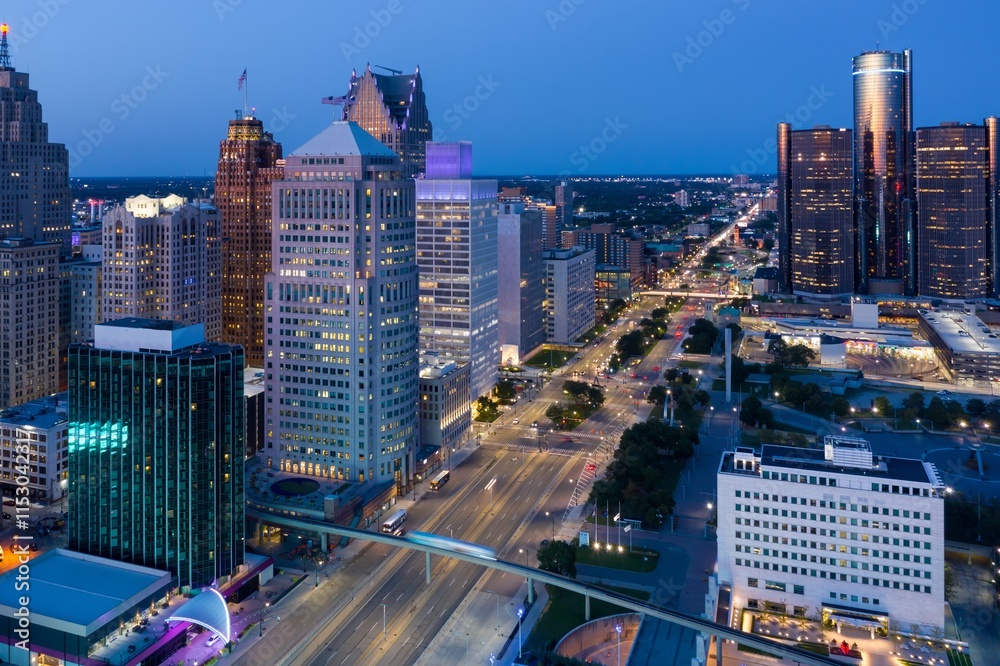 Fototapeta premium Detroit skyline at twilight, aerial view. City lights illuminate skyscrapers and traffic flows below. DOWNTOWN, DETROIT, MICHIGAN, UNITED STATES