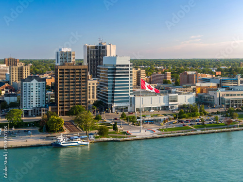 Carta da parati Aerial view of a city waterfront, featuring modern buildings, a Canadian flag, and a ferry docked