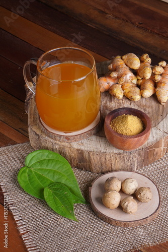 herbal drink made from turmeric, betel leaves and oak galls photographed in a studio setting with traditional Indonesian theme props
