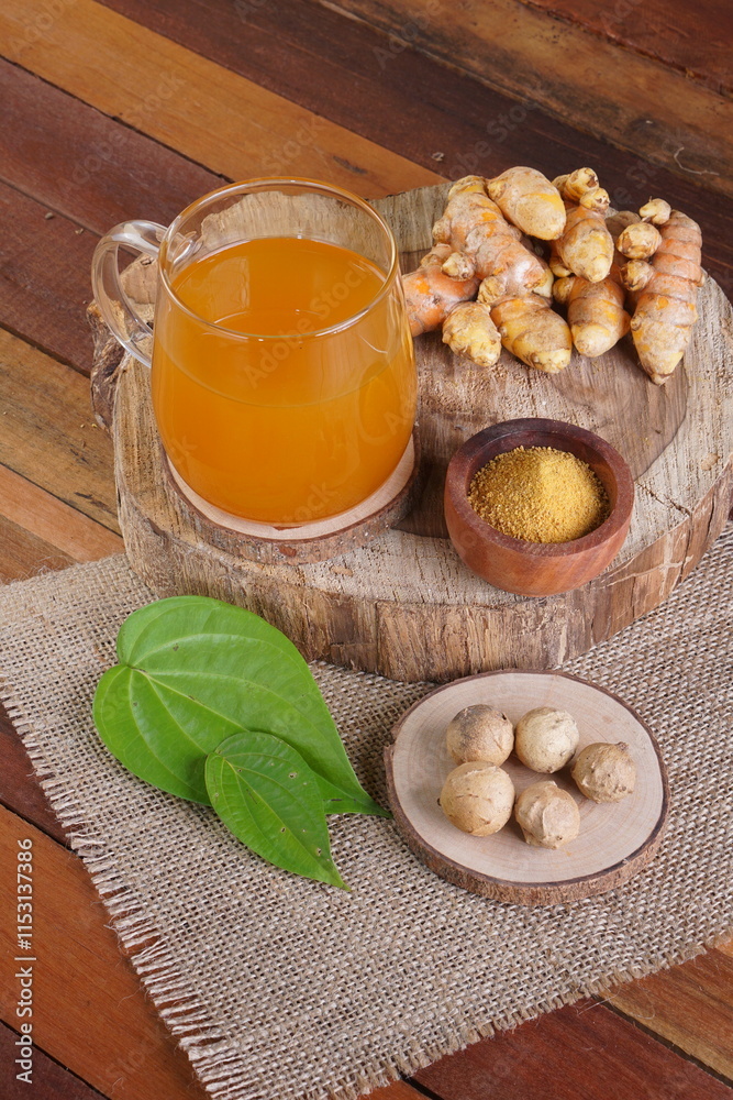 Fototapeta premium herbal drink made from turmeric, betel leaves and oak galls photographed in a studio setting with traditional Indonesian theme props