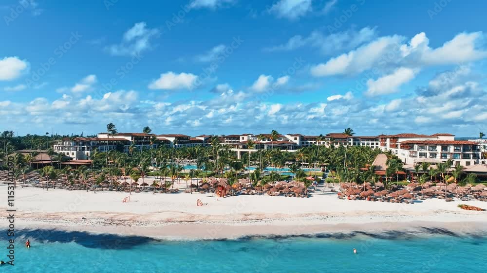 Palm resort beach of tropical island against blue sky with white clouds. Blue ocean on white coast on sunny day. Perfect natural landscape for summer vacation. Holiday vacation background. Palm resort beach of tropical island against blue sky with white clouds. Blue ocean on white coast on sunny day. Perfect natural landscape for summer vacation. Holiday vacation background.