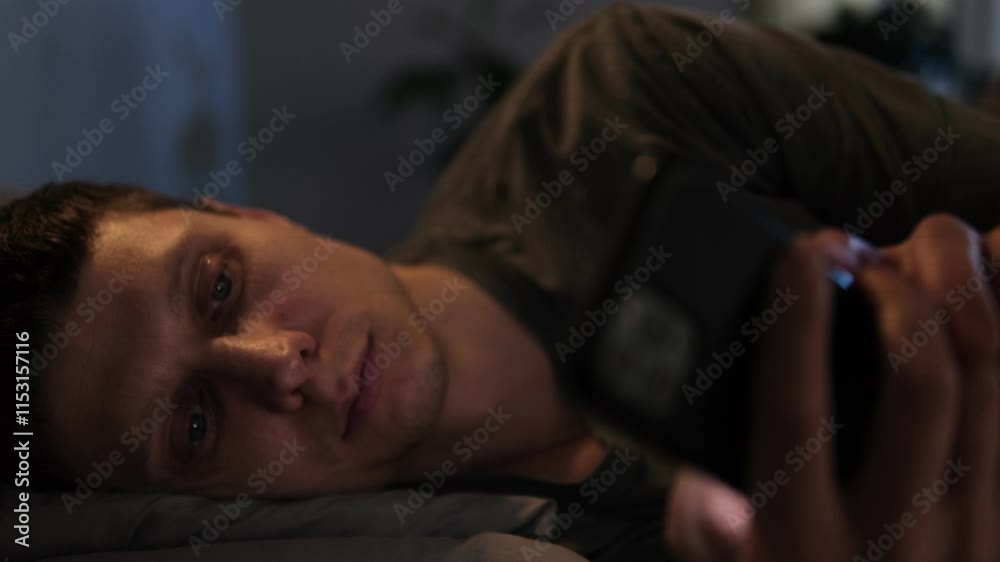 Man scrolls through his phone at night in bed, losing sleep due to social media and fast-paced video content. Man scrolls through his phone at night in bed, losing sleep due to social media and fast-paced video content.