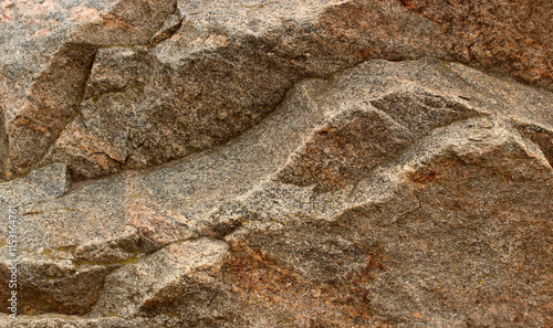 Texture of raw pale red granite stone stock photo for backgrounds. Hi-res stock image of rough granite pattern