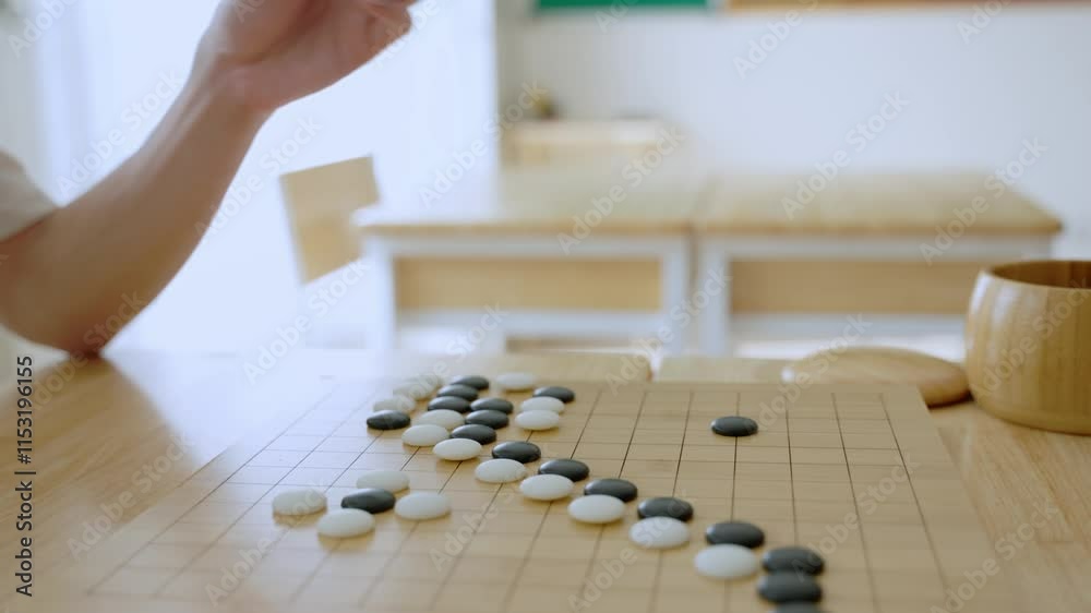 Close up of young men play board game Go during competition in community.