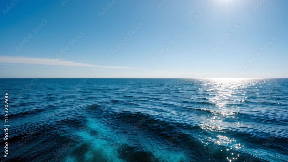 Fototapeta premium Expansive ocean view with shimmering sunlight, calm waves, and a clear blue sky stretching endlessly.