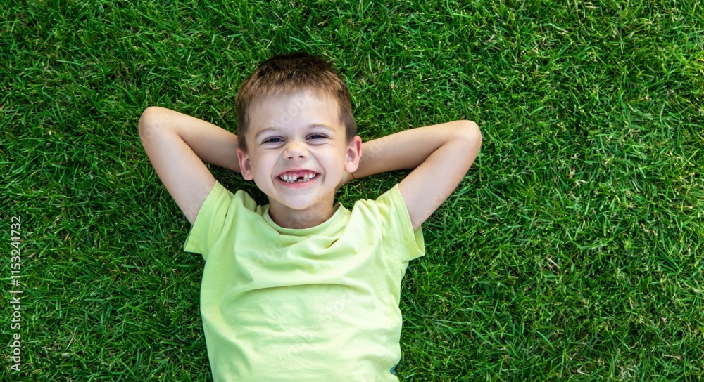 Smiling and happy boy lying on green grass. Children. Smiling and happy boy lying on green grass. Children.