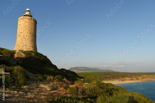 Lighthouse with coastal background in a scenic landscape.