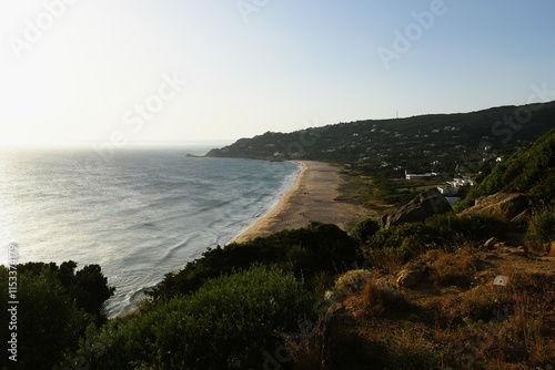 Cove with sandy coast and green hills.