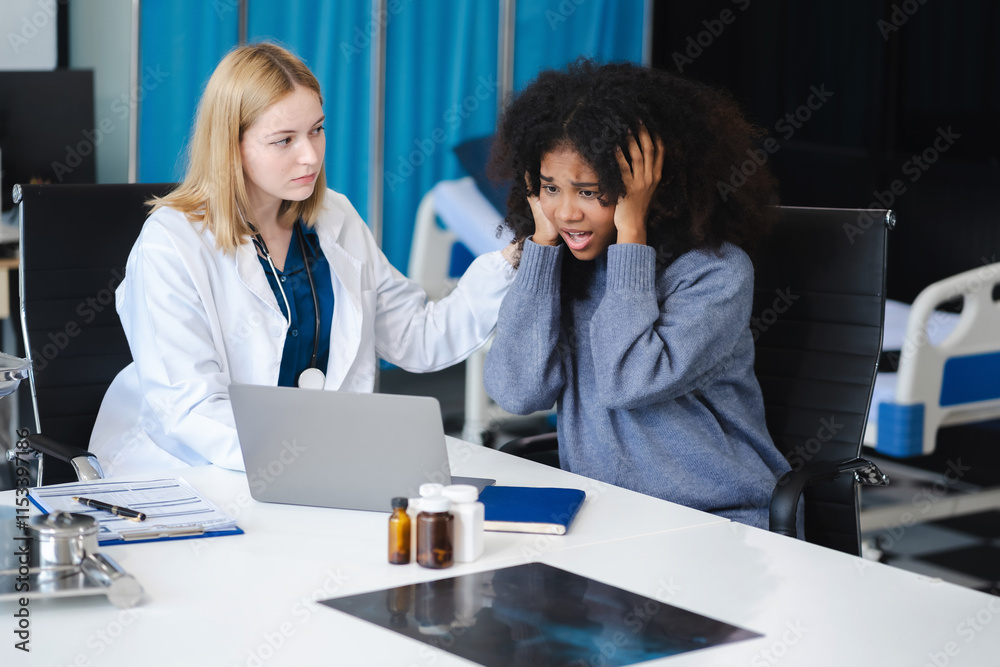 Female doctor consulting patient using x-ray film analyzed the results of medical reports, talking to patient and touching patient hand and consoling. Female doctor consulting patient using x-ray film analyzed the results of medical reports, talking to patient and touching patient hand and consoling.