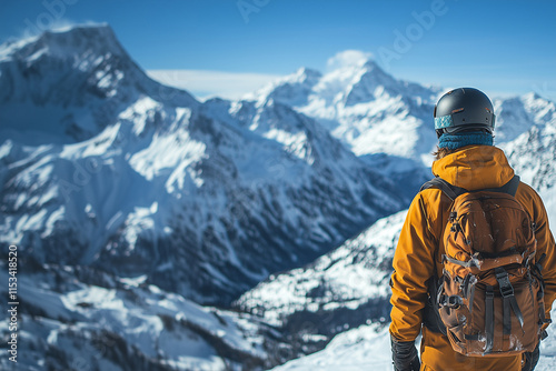 Wallpaper Mural A snowboarder wearing an orange jacket and a black helmet stands on top of a mountain Torontodigital.ca