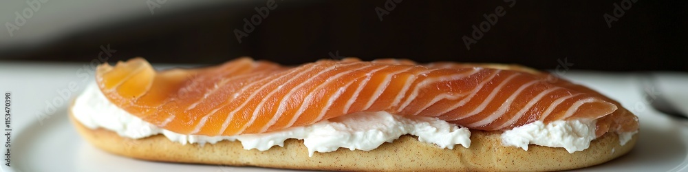 neatly arranged slice of smoked salmon resting on bagel with cream cheese under soft directional light neatly arranged slice of smoked salmon resting on bagel with cream cheese under soft directional light
