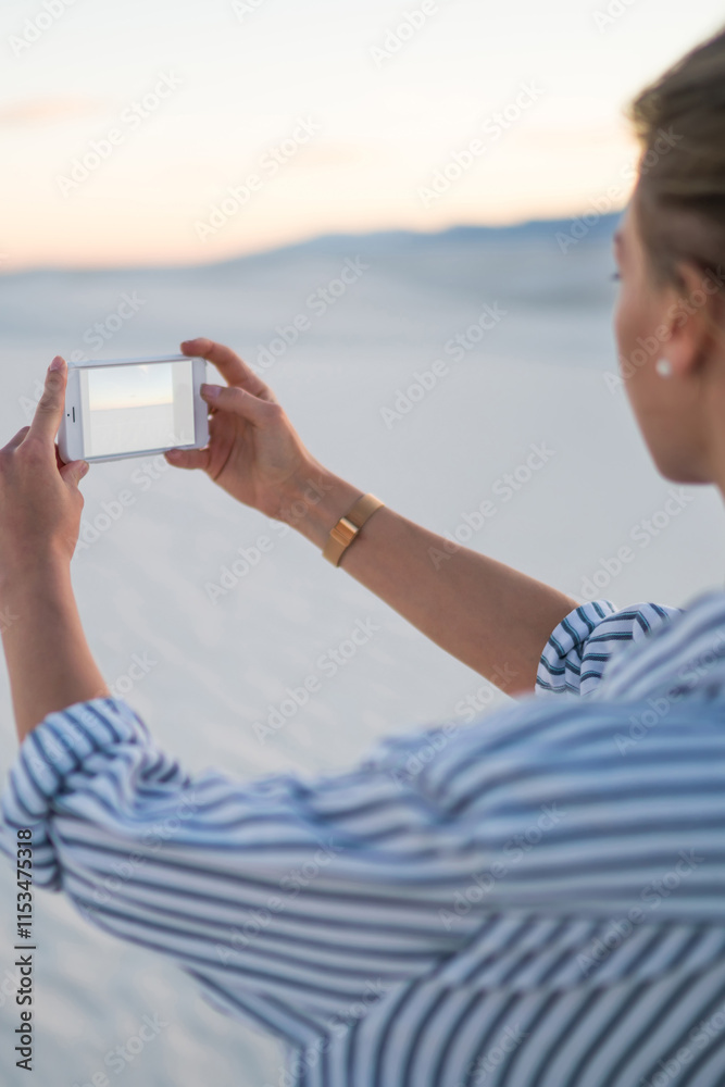 Φωτογραφία Back view of female holding smartphone making picture of beautiful nature of Whi