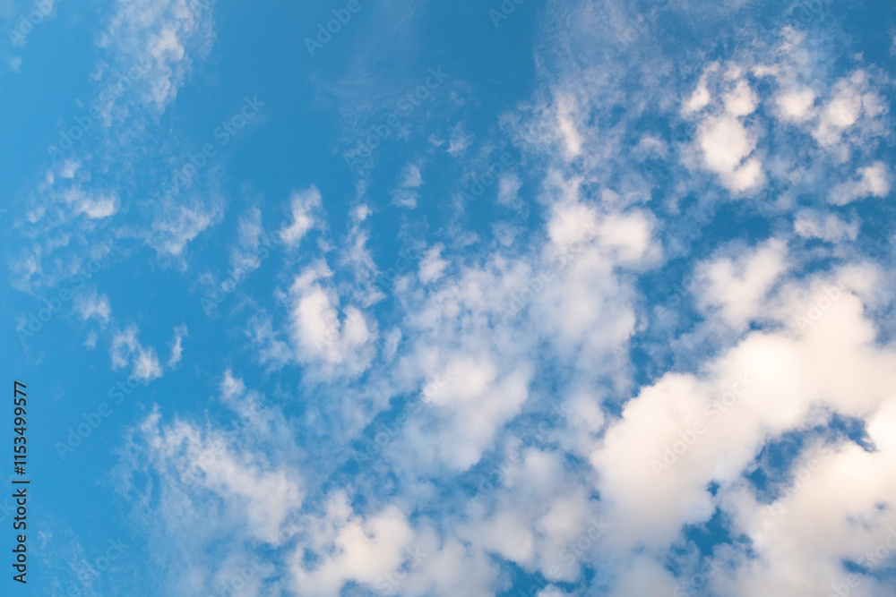 Obraz premium Blue Sky with Wispy Clouds at Sunset. This sky photo is perfect for backgrounds, themes of tranquility, nature, or freedom, and can be used in designs related to relaxation, inspiration or the outdoor
