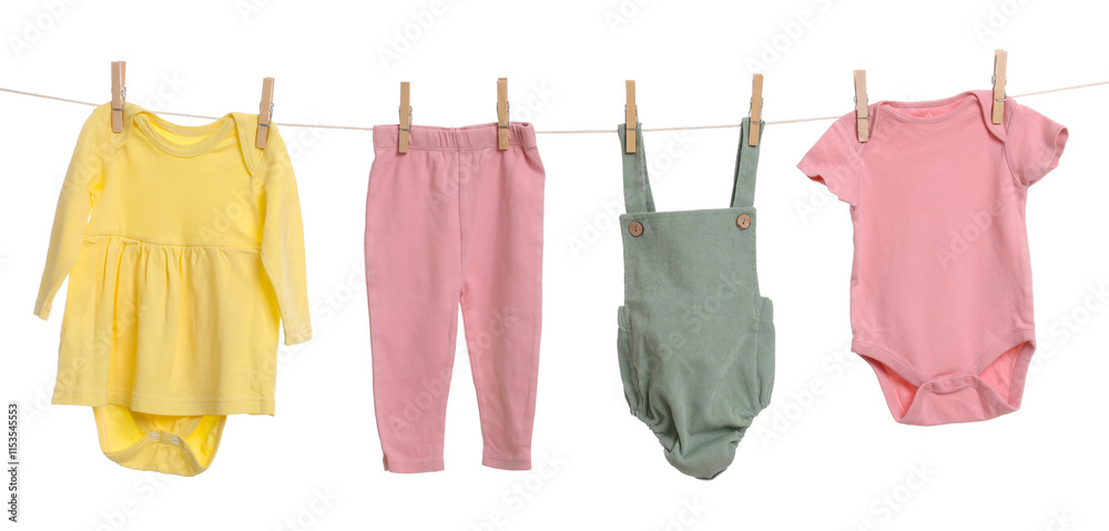 Different baby clothes drying on laundry line against white background Different baby clothes drying on laundry line against white background