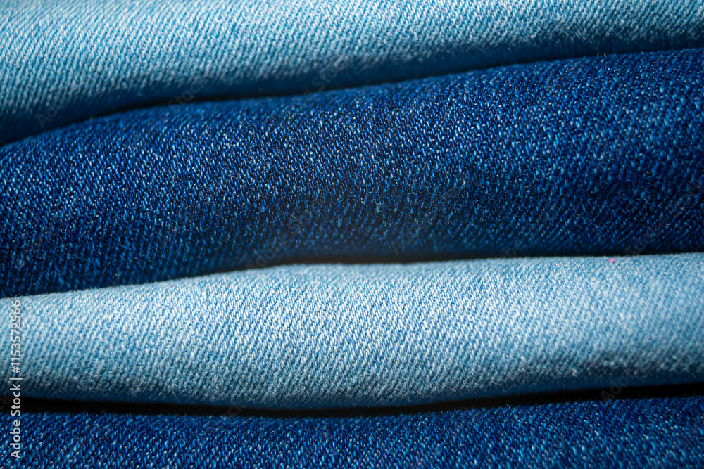 Textured layers of folded jeans fabric showcasing varying shades of blue Textured layers of folded jeans fabric showcasing varying shades of blue
