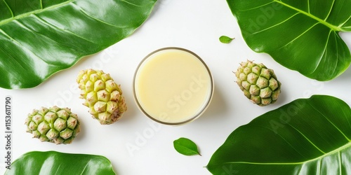 Noni juice displayed in a clear glass alongside fresh noni fruit and vibrant green leaves, all set against a clean white background, highlighting the essence of noni juice.