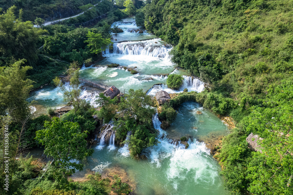 Lush forest and turquoise waterfall flowing through the valley in countryside