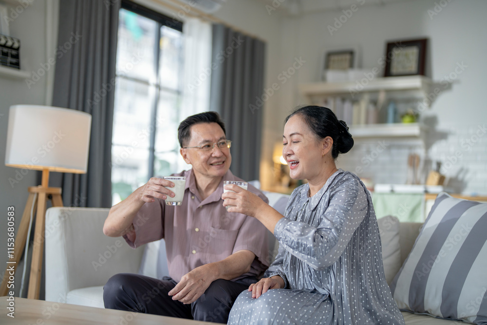 An elderly couple enjoys a peaceful moment at home, sharing smiles and drinks. The warm and cozy atmosphere emphasizes their deep connection, happiness, and the comfort of spending time together. An elderly couple enjoys a peaceful moment at home, sharing smiles and drinks. The warm and cozy atmosphere emphasizes their deep connection, happiness, and the comfort of spending time together.