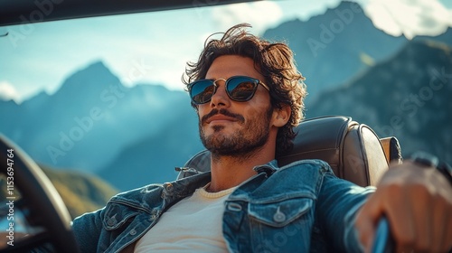 A man with medium-length brown hair and sunglasses is driving a car with his hands on the steering wheel. photo