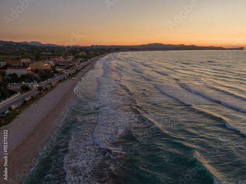 Coastal sunset view of beach and ocean waves gently rolling ashore. photo