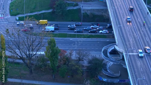 Drone high angle overview of Gdanski bridge and Wislostrada in Warsaw, showing cars and crossing traffic over roads and train tracks at blue hour photo