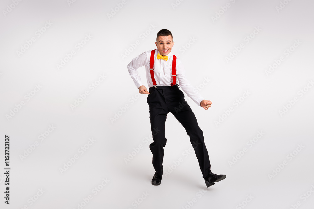 Dynamic young man in retro fashion dancing happily with energetic movements and vibrant expression on white background Dynamic young man in retro fashion dancing happily with energetic movements and vibrant expression on white background